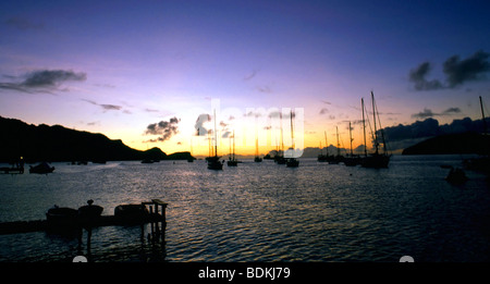 A  fleet of sailboats and yachts embrace Admiralty Bay on Bequia, St. Vincent and the Grenadines near dusk. Stock Photo