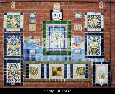 Old ceramic wall tiles on a house brick wall in Ludlow. Shropshire, England