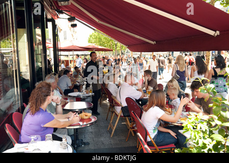 France cafe; Waiter serving people in a  busy street cafe on the Champs Elysee, Paris France Stock Photo