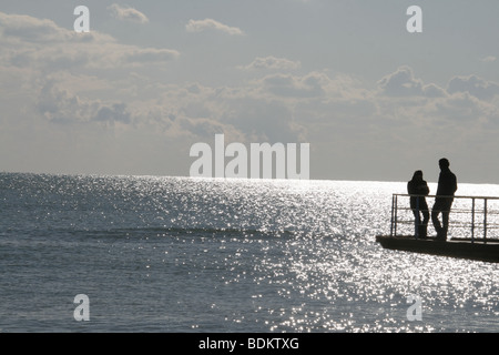 young teen couple taking photo on pier by sea Stock Photo