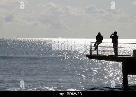 young teen couple taking photo on pier by sea Stock Photo