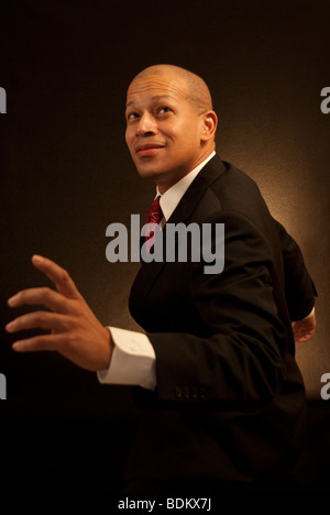 Business man superhero. African American business man in a suit and tie striking an action pose. Stock Photo