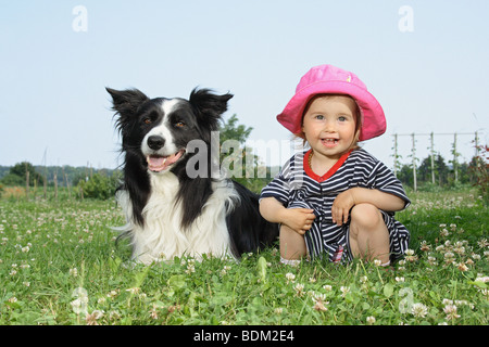 Border Collie dog - lying next to a little girl Stock Photo