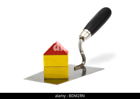 small house built of toy blocks on a bricklayer's trowel, isolated on white background Stock Photo