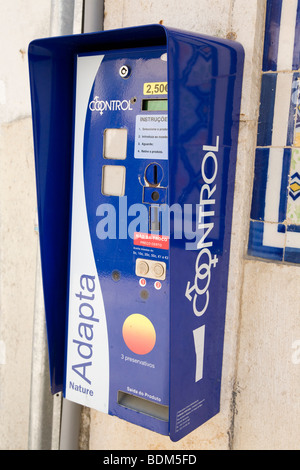 A condom vending machine hangs on a wall in a street in Portugal. Stock Photo