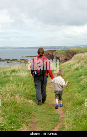 A mother and son walking on the Pembrokeshire coastal path Stock Photo