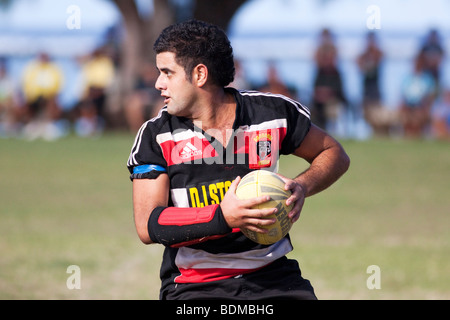A player holding the ball during rugby game on Rarotonga in The Cook Islands next to the sea Stock Photo
