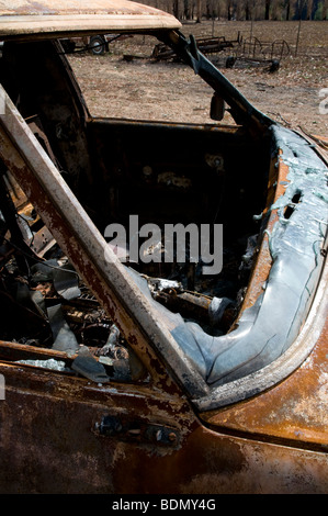 Burnt out car after a bushfire Stock Photo