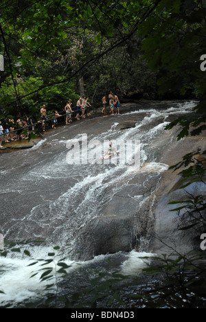 A young person slides down a flat rock water slide in North Carolina. Stock Photo