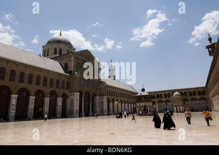 Veiled women in black and casually dressed men walk through the courtyard of the Umayyad Mosque (Grand Mosque of Damascus), carr Stock Photo