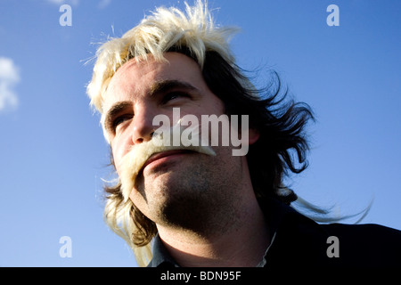Man pictured wearing a bright blonde wig whilst attending a crick match at Sussex Cricket Clubs home ground in Hove, Sussex, UK. Stock Photo