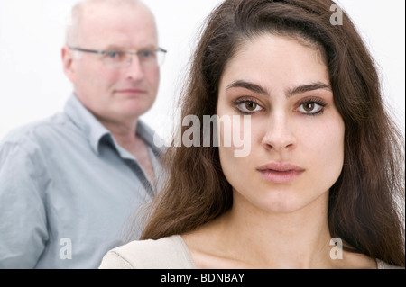 Girls with long, dark hair, friendly looking man in the back Stock Photo