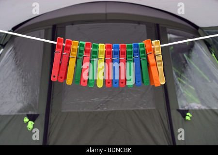 Clothes pegs hanging on a line outside a family tent Stock Photo