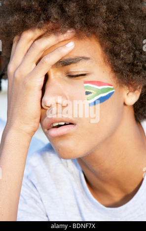 Sports fan with South African flag painted on his cheek looking disappointed. Cape Town, Western Cape Province, South Africa Stock Photo