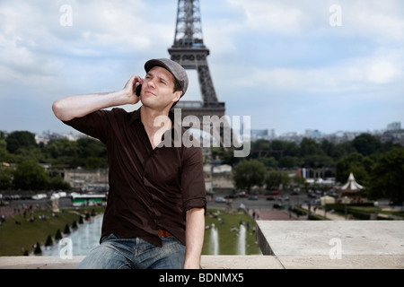 Young man in front of the Eiffel Tower, Paris, France, Europe Stock Photo