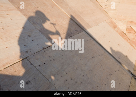 Shadow of carpenter on the roof of an under construction house Stock Photo