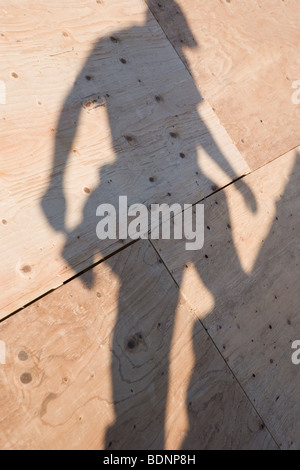 Shadow of carpenter on the roof of an under construction house Stock Photo