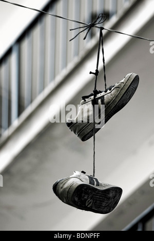 A pair of training shoes hanging on a line Stock Photo