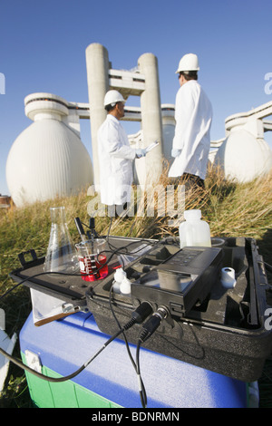 Water sample and PH meter with two scientists in the background Stock Photo