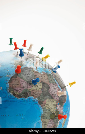 Push pins in various parts of globe, studio shot Stock Photo