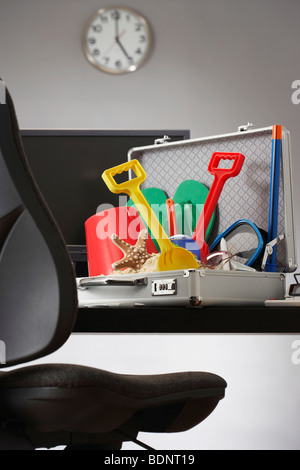 Beach toys in open business case in office Stock Photo