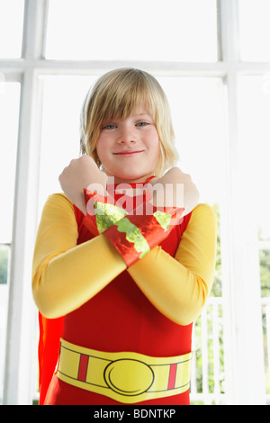 Portrait of boy (7-9) wearing superhero costume, arms crossed, smiling