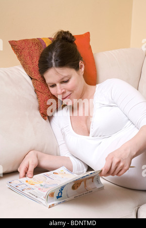 Young pregnant woman lays on bed wearing lacy bra and panties with her naked  pregnant belly. Relaxed and peaceful in this resting position, touching t  Stock Photo - Alamy