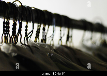 Dry cleaned clothes hanging on a rail Stock Photo