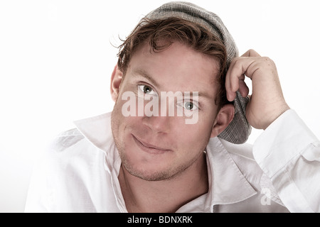 Portrait of a young, smiling man wearing a white shirt and a hat Stock Photo