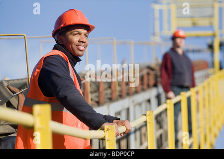 Engineers standing on a conveyor belt at a construction site Stock Photo