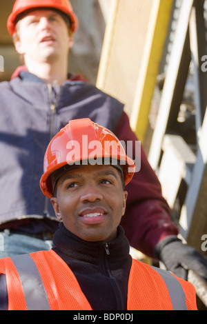 Two engineers on a conveyor belt at a construction site Stock Photo