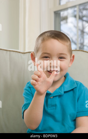 Boy signing the letter 'L' in American Sign Language Stock Photo