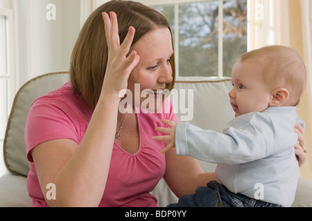 Woman signing the word 'Dad' in American Sign Language while communicating with her son Stock Photo