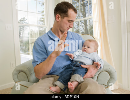 Man signing the word 'B' in American Sign Language while communicating with his son