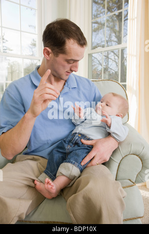 Man signing the word 'D' in American Sign Language while communicating with his son