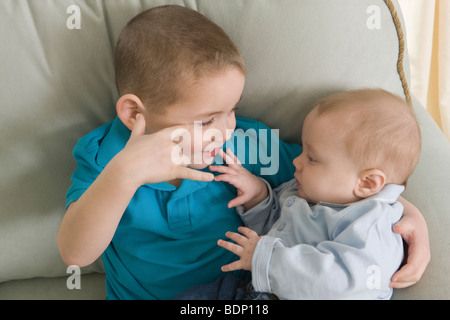 Boy signing the phrase 'I Love You ' in American Sign Language while communicating with his brother Stock Photo