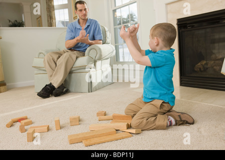 Man signing the word 'Help' in American Sign Language while communicating with his son Stock Photo