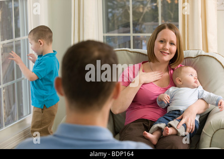 Woman signing the word 'Happy' in American Sign Language while communicating with a man Stock Photo