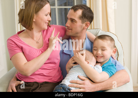 Woman signing the phrase 'I Love You' in American Sign Language while communicating with a man