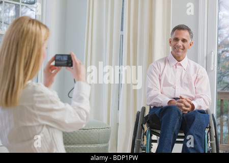Woman taking a picture of a man with a digital camera Stock Photo