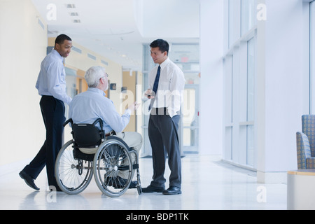 Three university professors talking in a corridor of a university Stock Photo