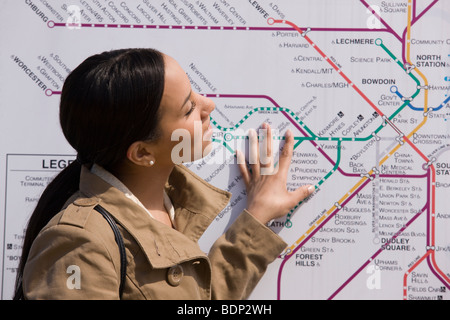 Hispanic woman looking at a route map at a subway station Stock Photo