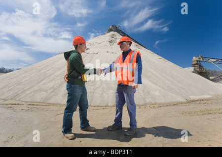 Two engineers shaking hands at a plant Stock Photo