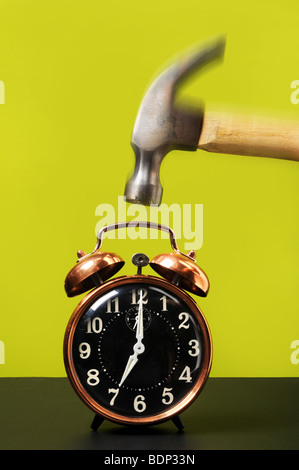 Vintage alarm clock and hammer falling Stock Photo