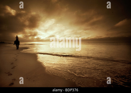 Figure riding a horse on a sandy beach Stock Photo