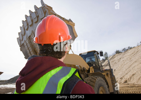 Engineer looking at a front-end loader at a construction site Stock Photo