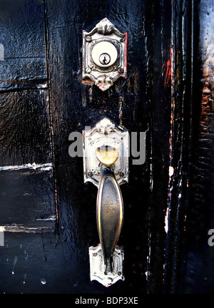 A silver door knocker on a black door Stock Photo