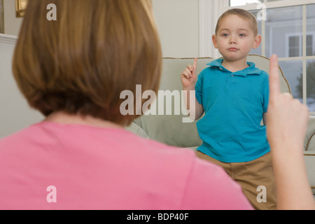 Woman signing the number '1' in American Sign Language while communicating with her son Stock Photo