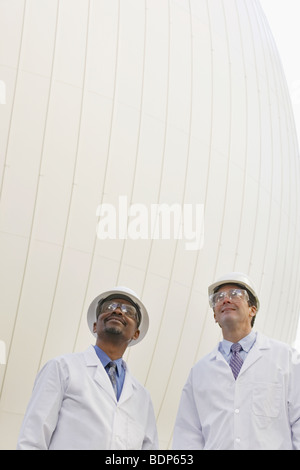 Two scientists standing in front of a digester tank Stock Photo
