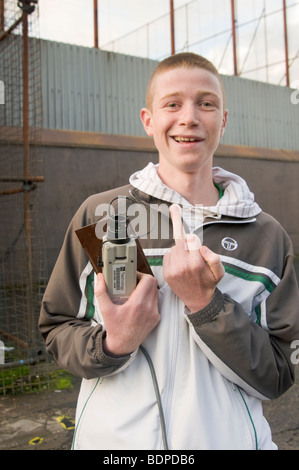 Youth gives the finger while carrying the innards of a CCTV camera, taken from a police station. Stock Photo